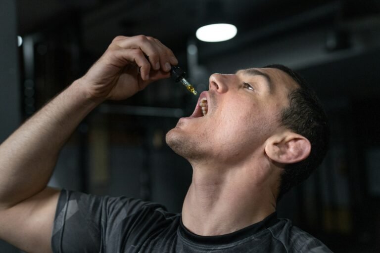 Man taking CBD oil drops with a dropper under his tongue for fast absorption.
