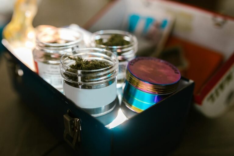 Glass jars of cannabis buds with grinder stored in a metal box