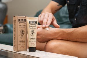 Person applying R+R Medicinals hemp extract infused cream 1000mg full spectrum