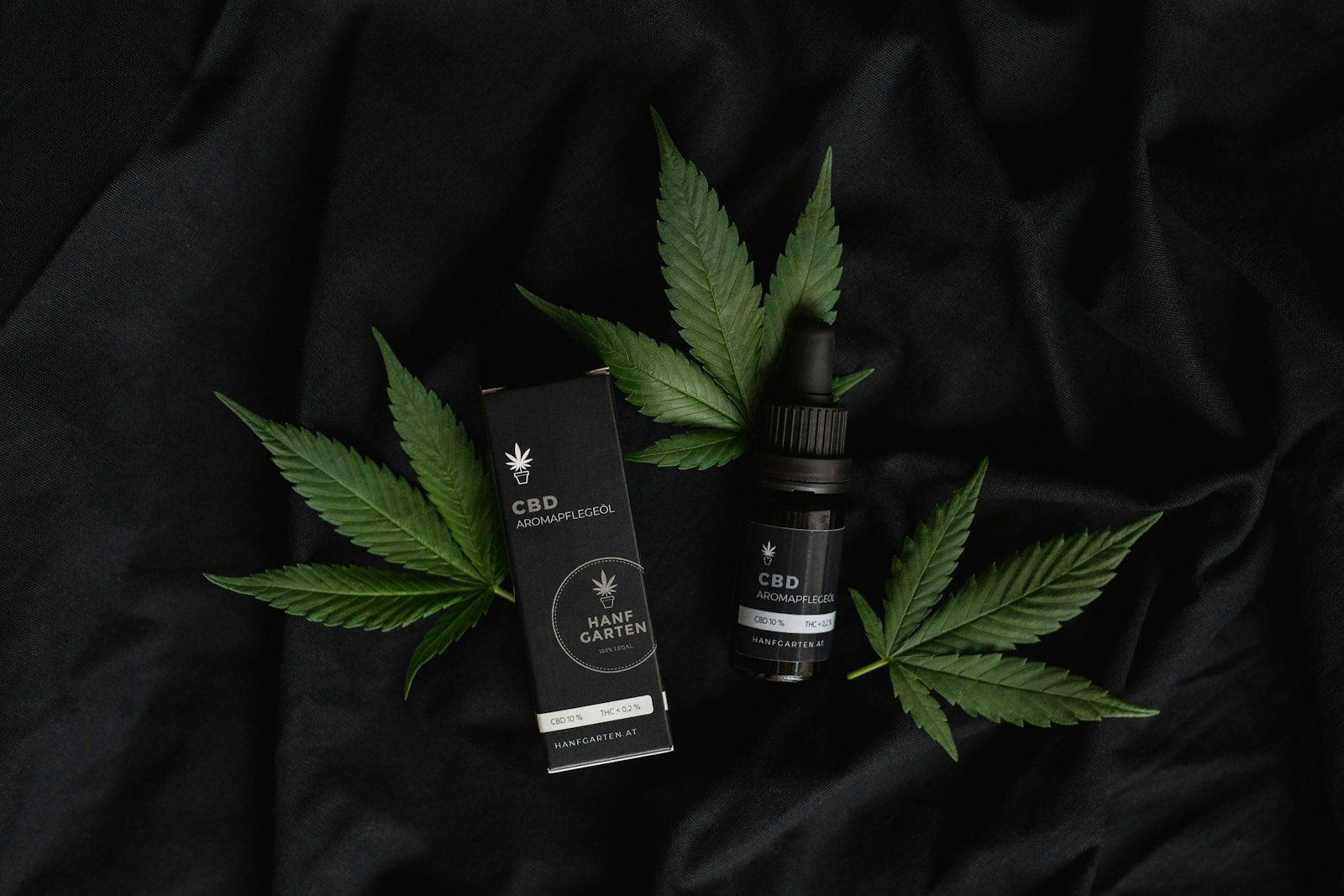 CBD oil droppers and Shokobud CBD chocolate jar on reflective surface